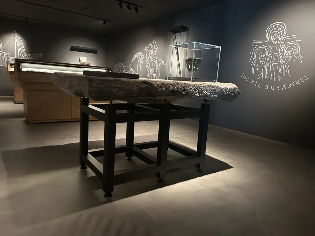 Museumudstilling med runesten og vægillustrationer