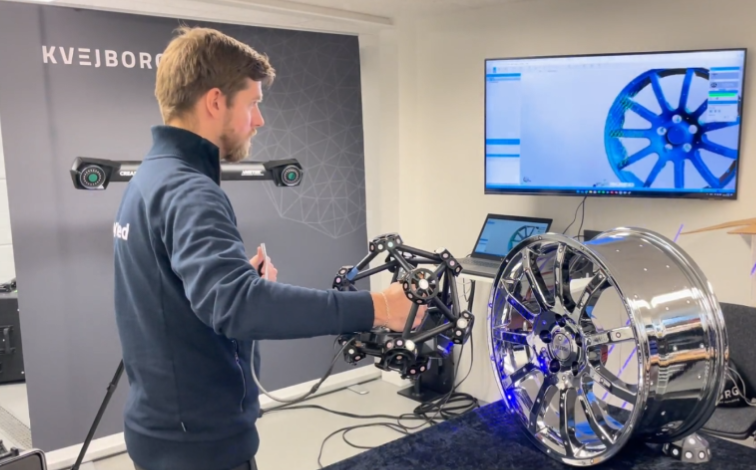 Mand bruger 3D-scanner på bilfælg i værkstedet.
